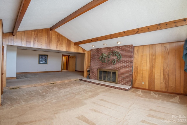 3616 County Home Rd, Conover, NC 28613 - unfurnished living room featuring visible vents, wooden walls, a fireplace, carpet flooring, and vaulted ceiling with beams