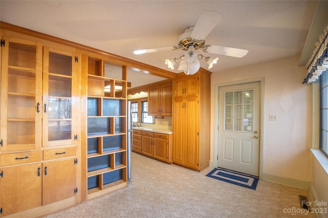 3616 County Home Rd, Conover, NC 28613 - kitchen with brown cabinetry, baseboards, a ceiling fan, and light countertops