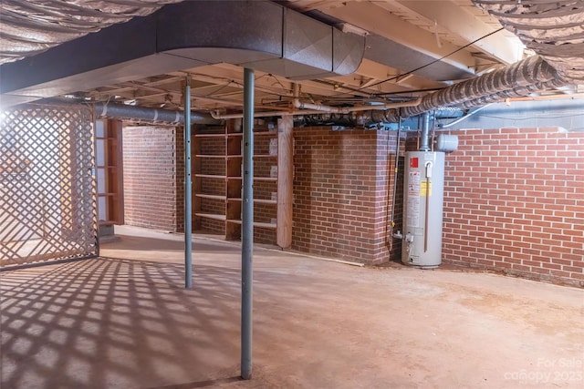 basement featuring brick wall and gas water heater