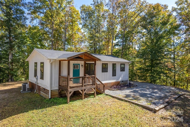 view of front of home with central AC and a front lawn