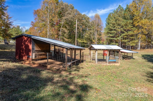 rear view of property featuring a yard and an outdoor structure