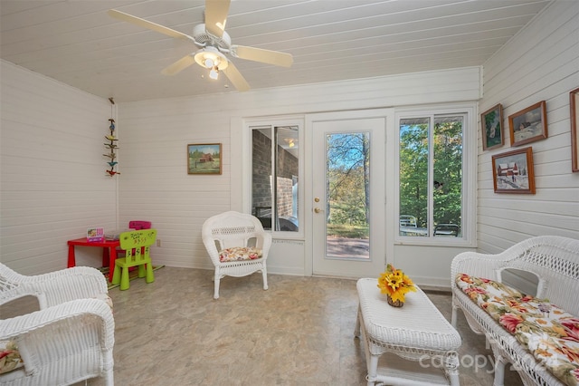 game room featuring wood walls and ceiling fan