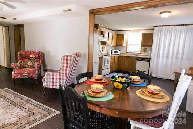 dining space featuring dark hardwood / wood-style flooring, ceiling fan, and sink