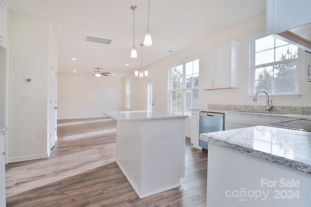 kitchen featuring a healthy amount of sunlight, hanging light fixtures, white cabinetry, and light wood-type flooring