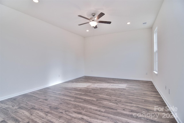 unfurnished room featuring wood-type flooring, plenty of natural light, and ceiling fan