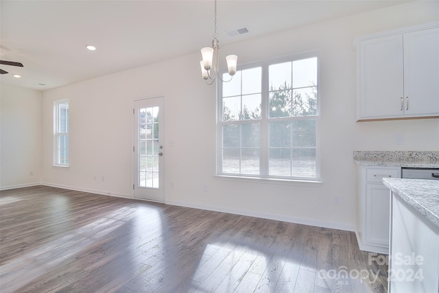 unfurnished dining area with wood-type flooring and ceiling fan with notable chandelier