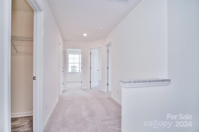 hallway featuring light colored carpet