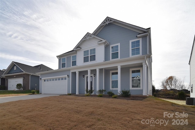 view of front of property with central AC, covered porch, a front yard, and a garage