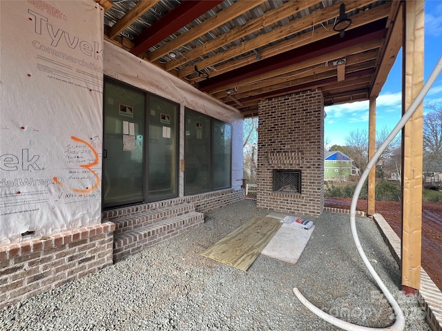 view of patio featuring an outdoor brick fireplace