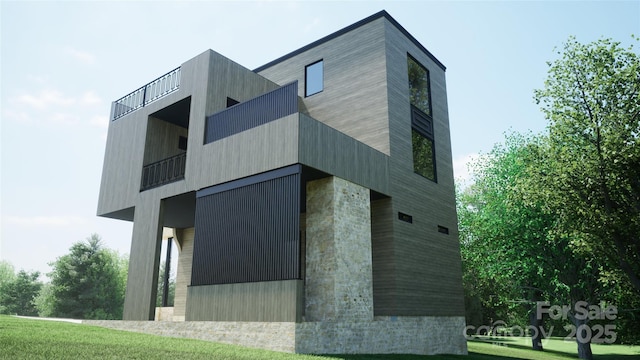 view of side of home with a balcony and a lawn