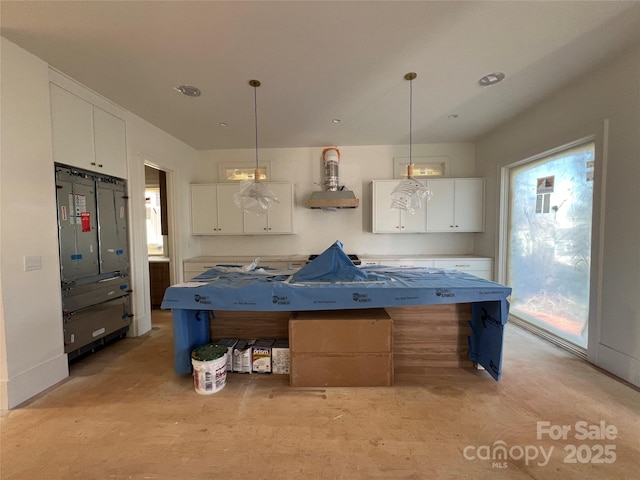 kitchen with white cabinetry, wall chimney exhaust hood, and pendant lighting