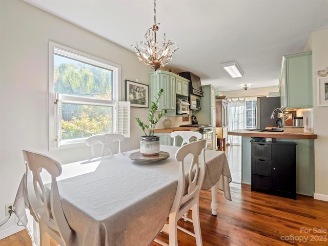 dining space with an inviting chandelier and dark hardwood / wood-style flooring