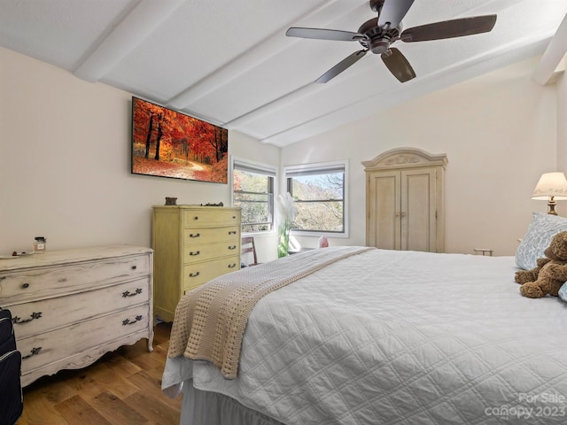 bedroom featuring ceiling fan, hardwood / wood-style floors, and vaulted ceiling with beams