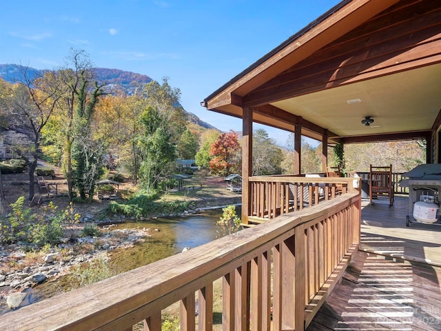 wooden deck with a water and mountain view