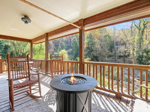 wooden terrace featuring an outdoor fire pit