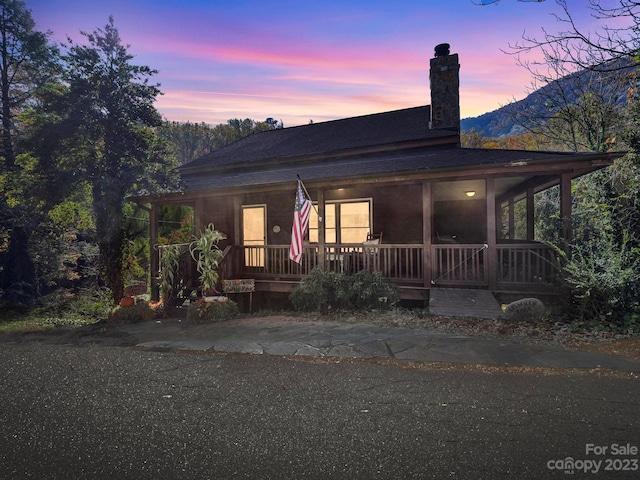 farmhouse with a mountain view and covered porch