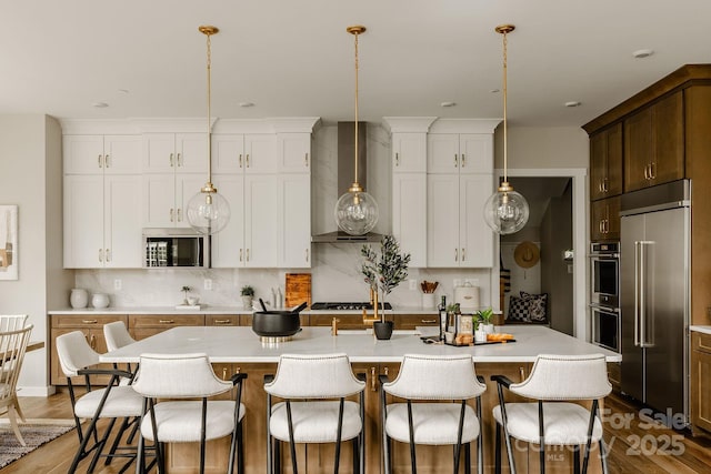 843 Lake Forest Drive Devonshire, Belmont, NC 28012 - kitchen featuring stainless steel appliances, wall chimney exhaust hood, light countertops, backsplash, and a kitchen bar