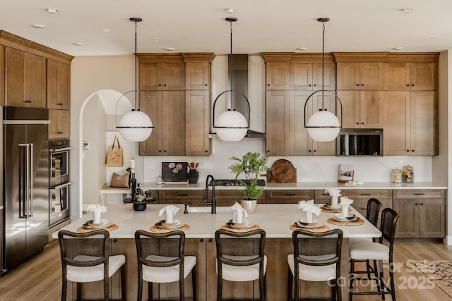 843 Lake Forest Drive Devonshire, Belmont, NC 28012 - kitchen with appliances with stainless steel finishes, light countertops, light wood finished floors, tasteful backsplash, and a kitchen bar