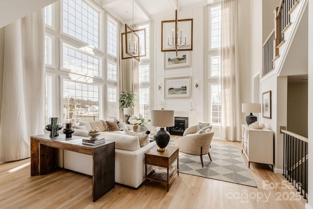 843 Lake Forest Drive Devonshire, Belmont, NC 28012 - living room with a high ceiling, light wood-type flooring, a chandelier, a glass covered fireplace, and plenty of natural light