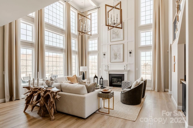 843 Lake Forest Drive Devonshire, Belmont, NC 28012 - living room with a towering ceiling, light wood-style floors, a glass covered fireplace, and a chandelier