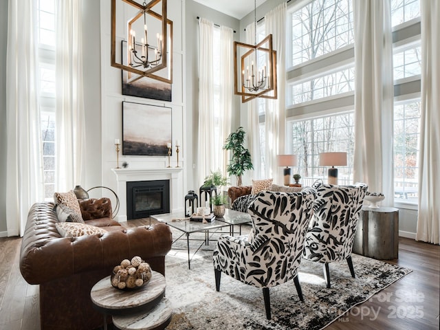 843 Lake Forest Drive Devonshire, Belmont, NC 28012 - living room featuring a chandelier, a glass covered fireplace, a towering ceiling, and wood finished floors