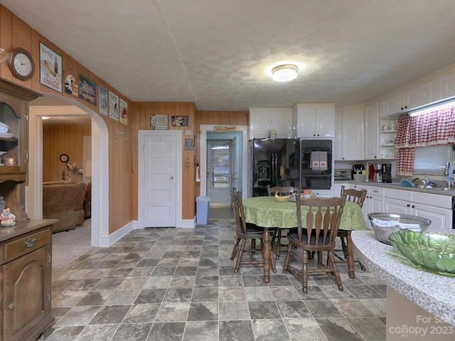 dining room featuring wooden walls and light tile floors