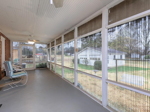 unfurnished sunroom featuring ceiling fan and a healthy amount of sunlight