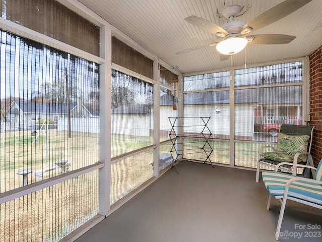 unfurnished sunroom with ceiling fan