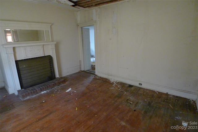 unfurnished living room with a brick fireplace and dark hardwood / wood-style floors