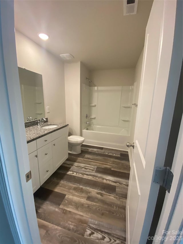 full bathroom with toilet, shower / tub combination, large vanity, and wood-type flooring