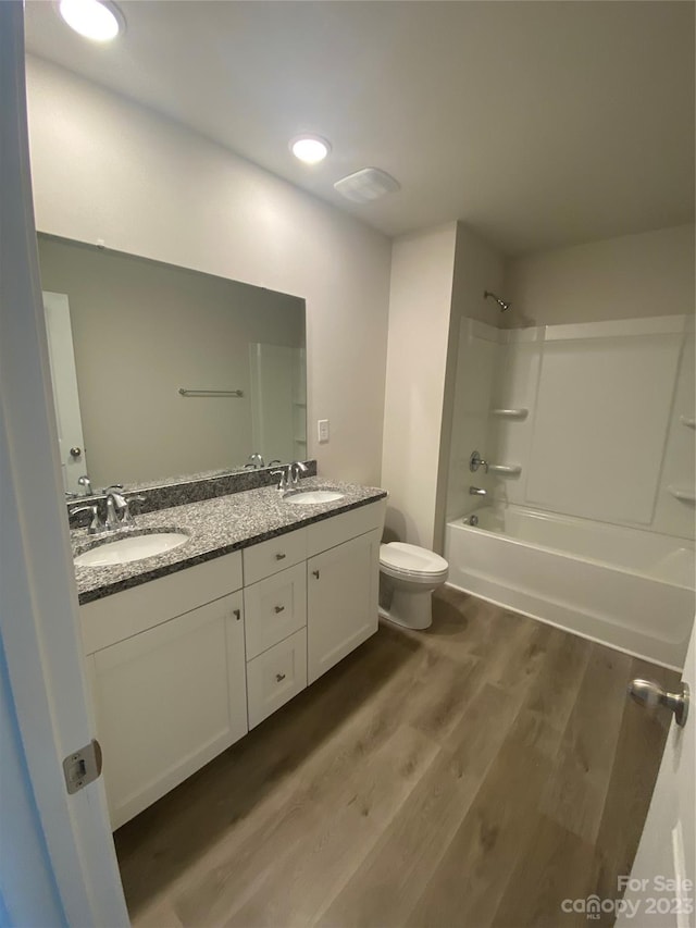 full bathroom featuring toilet, bathing tub / shower combination, double vanity, and wood-type flooring