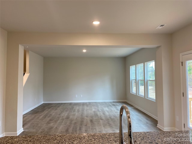 unfurnished room featuring dark hardwood / wood-style flooring and plenty of natural light