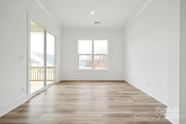 empty room featuring crown molding and light hardwood / wood-style floors