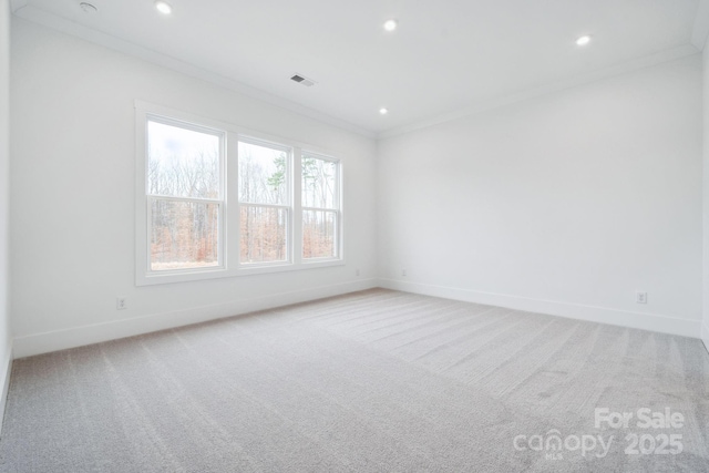 carpeted empty room featuring crown molding