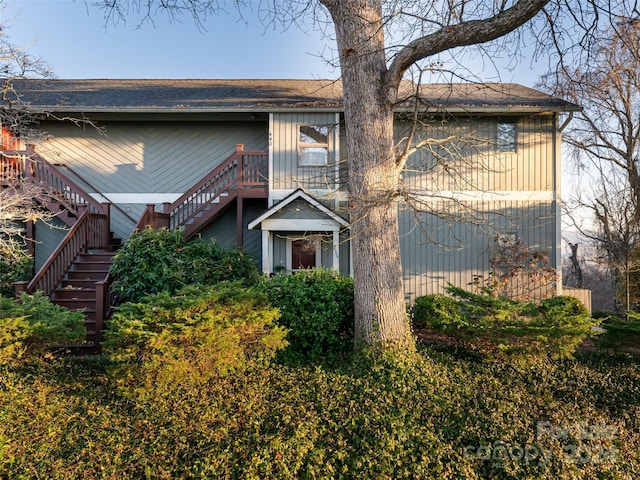 view of front of property with stairs and a shingled roof