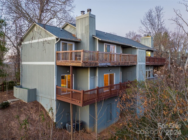 rear view of property with central AC unit and a balcony