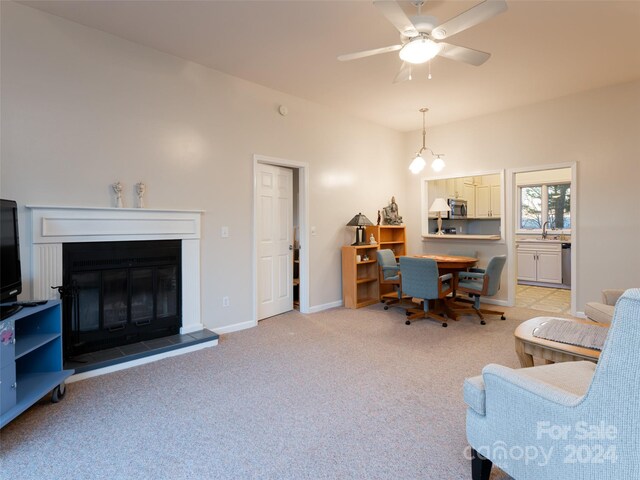 home office featuring ceiling fan with notable chandelier, light colored carpet, and sink