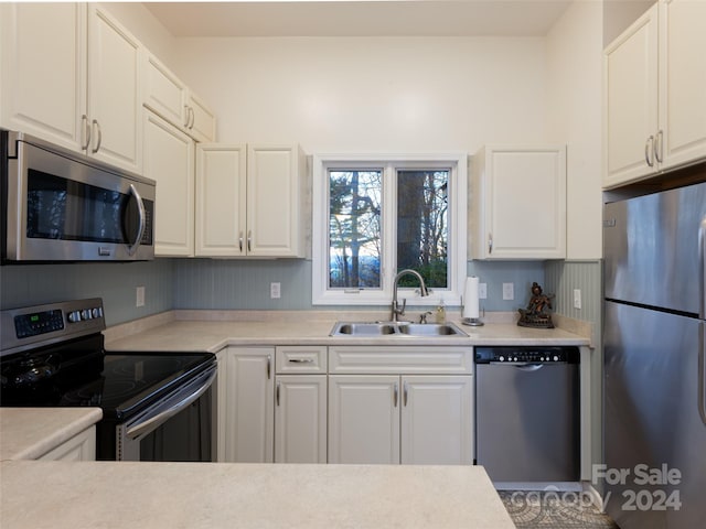 kitchen with appliances with stainless steel finishes, white cabinetry, and sink