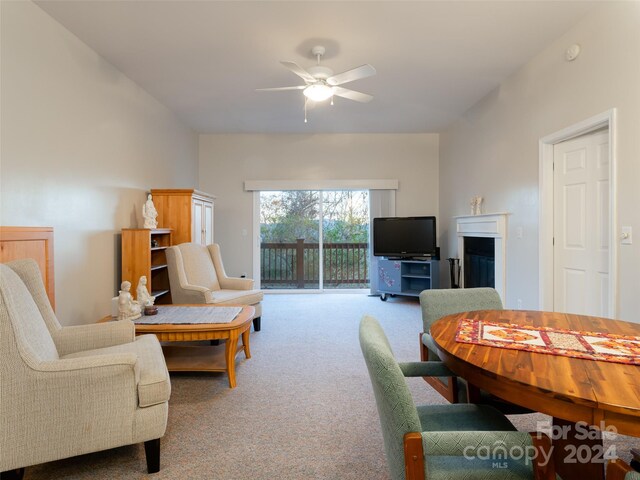 carpeted living room with ceiling fan