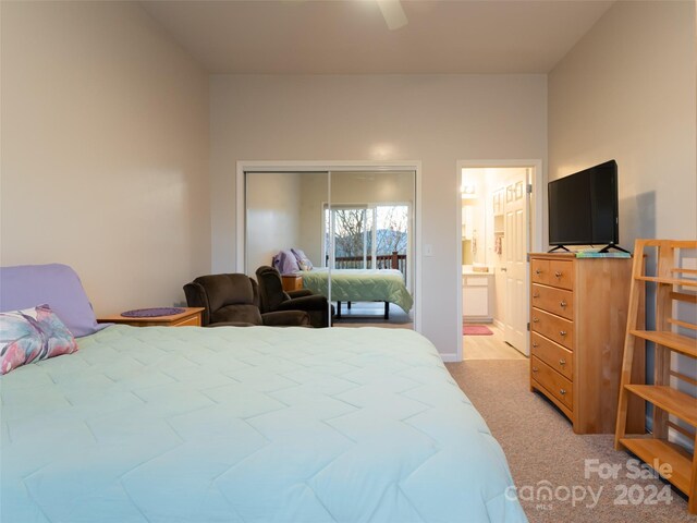 carpeted bedroom with ensuite bathroom, ceiling fan, and a closet