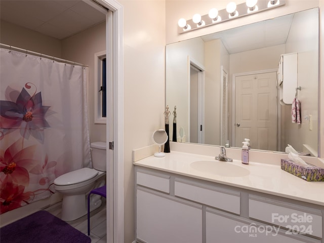 bathroom featuring vanity, toilet, and curtained shower