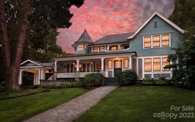 victorian-style house with covered porch and a lawn