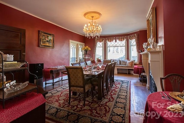 dining area featuring crown molding, an inviting chandelier, and dark hardwood / wood-style floors