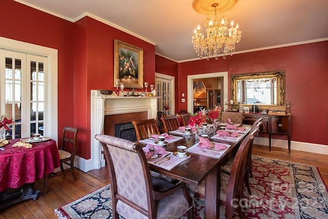 dining space featuring hardwood / wood-style floors, an inviting chandelier, and ornamental molding