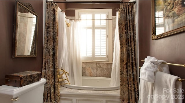 bathroom featuring toilet, a wealth of natural light, and shower / tub combo with curtain