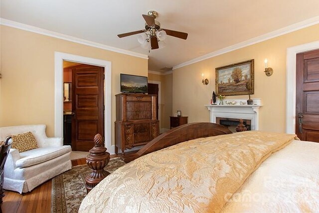 bedroom featuring crown molding, wood-type flooring, and ceiling fan