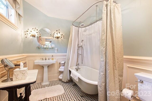 bathroom with tile patterned floors and shower / tub combo with curtain