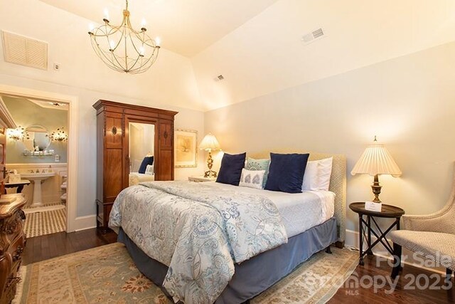 bedroom with lofted ceiling, dark hardwood / wood-style floors, and a notable chandelier