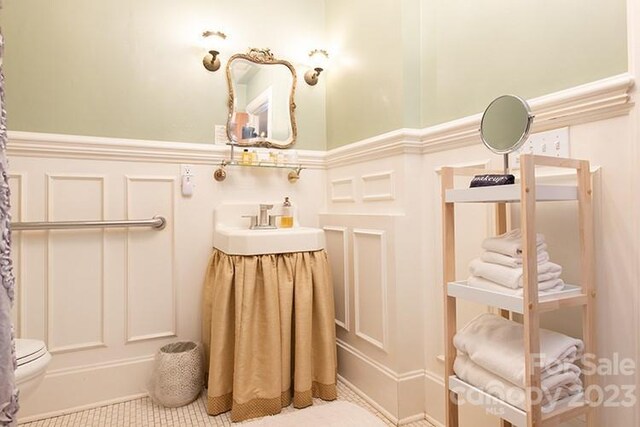 bathroom featuring sink, toilet, and tile patterned flooring