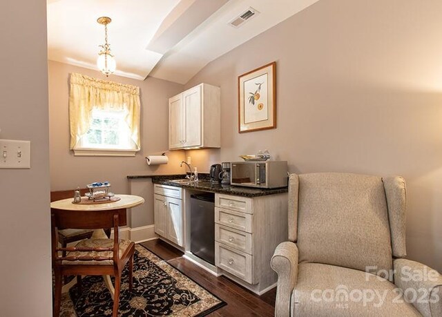 interior space featuring white cabinets, sink, pendant lighting, dark hardwood / wood-style flooring, and stainless steel appliances